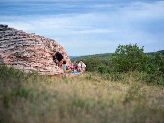 Œuvre d'art refuge Super-Cayrou, à Gréalou, au cœur des Causses du Quercy, Géoparc Mondial Unesco, sur le GR65. Cette double caselle en pierres sèches fait partie du parcours à ciel ouvert Fenêtres sur le paysage.