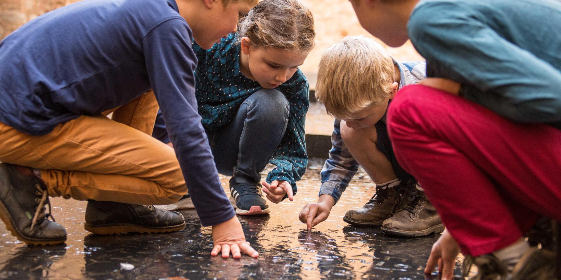 Enfant s'amusant sur l'emblème de Figeac