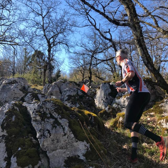Sportif en train à la recherche de balises lors d'une course d'orientation dans les Causses du Quercy.