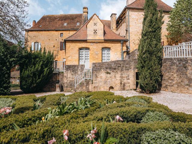 Jardin du Sénéchal en fleur, sous un ciel d'été, à Gourdon.